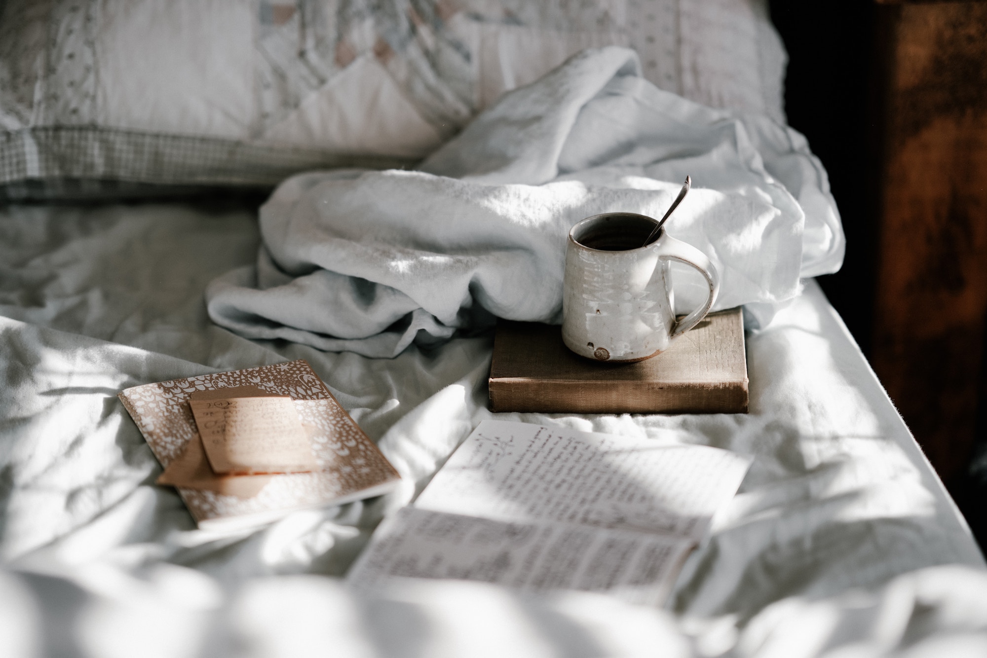 Mug and notebooks on bed